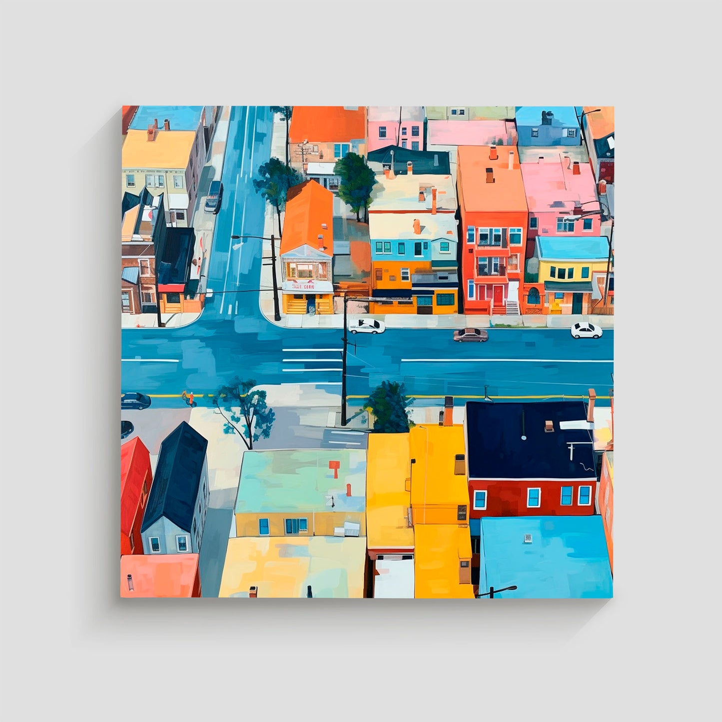 Imagen aérea de un barrio urbano con edificios de colores vivos y calles transitadas, mostrando intersecciones y coches circulando.